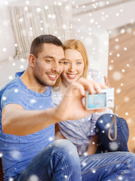 smiling couple taking picture with digital camera Stock photo © dolgachov
