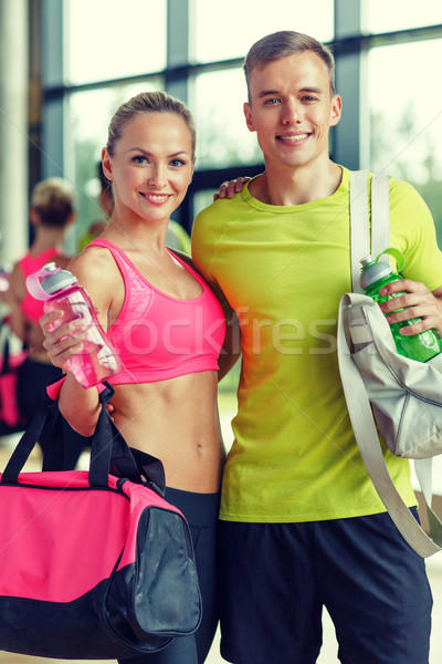 smiling couple with water bottles in gym Stock photo © dolgachov