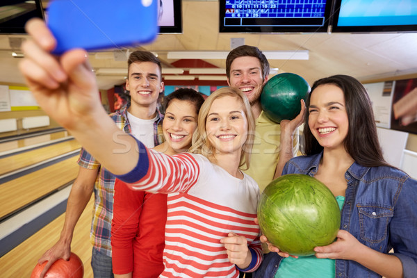 Fericit prietenii smartphone bowling club oameni Imagine de stoc © dolgachov