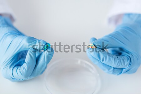 close up of scientist hands holding pill in lab Stock photo © dolgachov