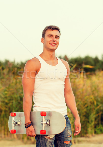 smiling teenage boy with skateboard outdoors Stock photo © dolgachov