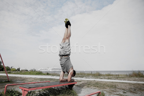 young man exercising on bench outdoors Stock photo © dolgachov