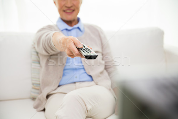 close up of happy senior woman watching tv at home Stock photo © dolgachov