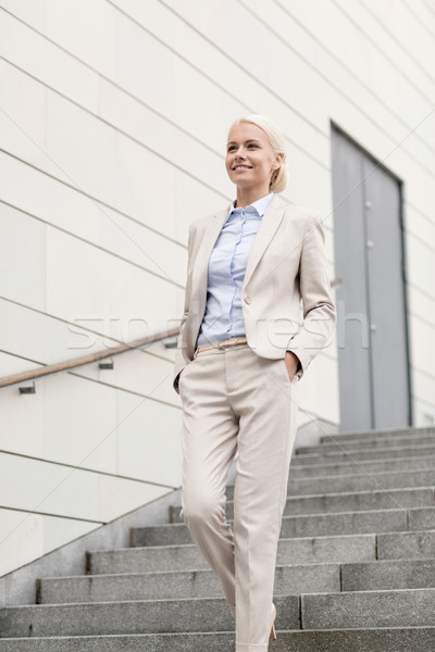 Jeunes souriant femme d'affaires marche vers le bas escaliers [[stock_photo]] © dolgachov