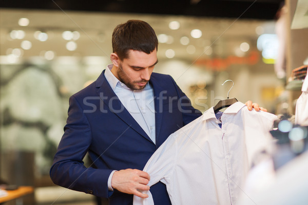 Glücklich junger Mann Auswahl Kleidung Kleidung Laden Stock foto © dolgachov