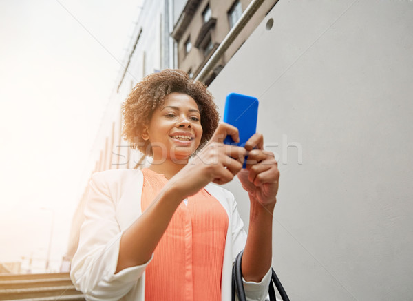 happy african woman with smartphone in city Stock photo © dolgachov