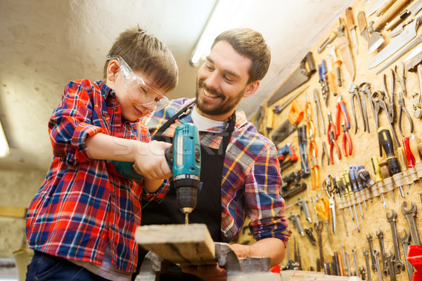 Stock photo: father and son with drill working at workshop