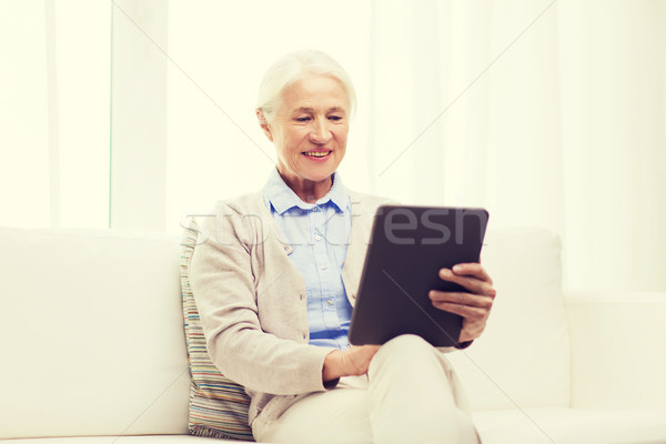 happy senior woman with tablet pc at home Stock photo © dolgachov