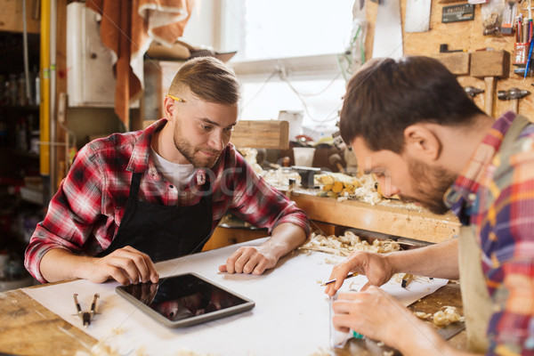 workmen with tablet pc and blueprint at workshop Stock photo © dolgachov