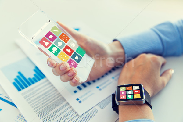 Stock photo: close up of hands with smart phone and watch icons