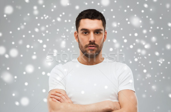 Stock photo: young man with crossed arms over snow background
