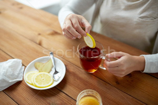 close up of woman adding lemon to tea cup Stock photo © dolgachov