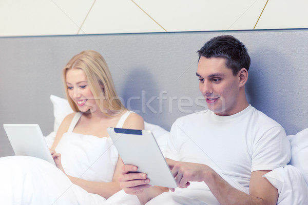 Stockfoto: Glimlachend · paar · bed · computers · hotel