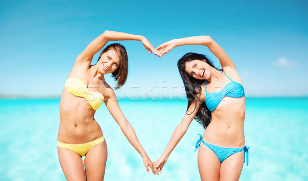 happy women making heart shape on summer beach Stock photo © dolgachov