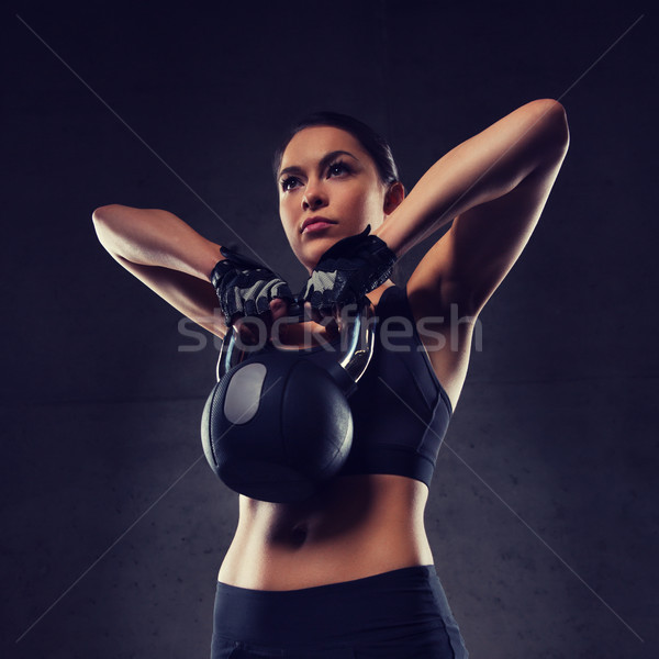 young woman flexing muscles with kettlebell in gym Stock photo © dolgachov
