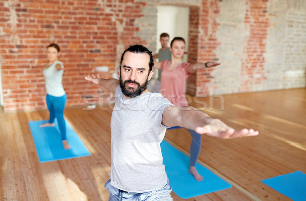 Foto stock: Grupo · de · personas · yoga · guerrero · plantean · estudio · fitness