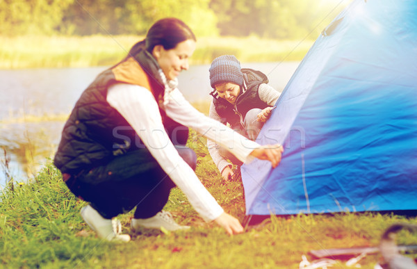 happy mother and son setting up tent outdoors Stock photo © dolgachov