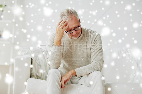 senior man suffering from headache at home Stock photo © dolgachov