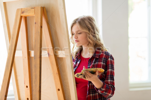 student girl with easel painting at art school Stock photo © dolgachov