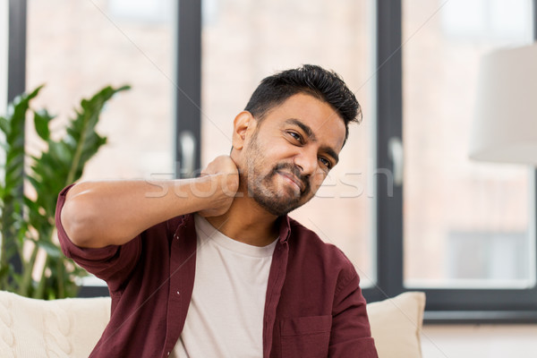 unhappy man suffering from neck pain at home Stock photo © dolgachov