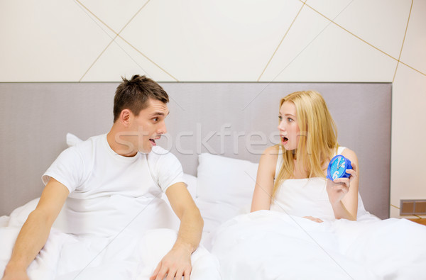 surprised couple with clock in bed Stock photo © dolgachov