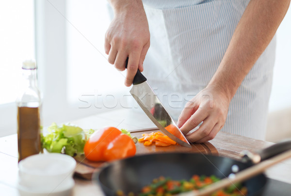 close up of male hand cutting pepper on board Stock photo © dolgachov