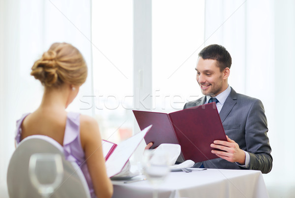 smiling young man looking at menu at restaurant Stock photo © dolgachov