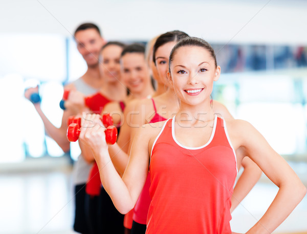 group of smiling people with dumbbells in the gym Stock photo © dolgachov
