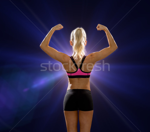 Stock photo: sporty woman from the back flexing her biceps
