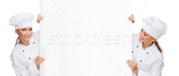 two smiling female chefs with white blank board Stock photo © dolgachov