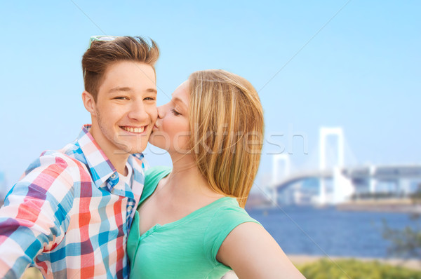 couple kissing and taking selfie over bridge Stock photo © dolgachov