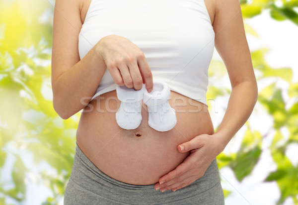 close up of pregnant woman with babys bootees Stock photo © dolgachov