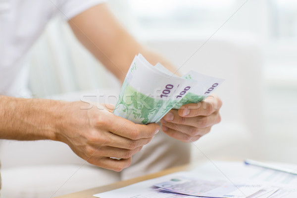 Stock photo: close up of man hands counting money at home