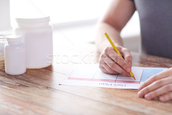 Stock photo: close up of man with protein jars and diet plan