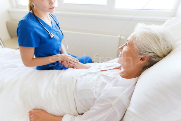 Stock photo: doctor or nurse visiting senior woman at hospital