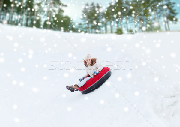 happy teenage girl sliding down on snow tube Stock photo © dolgachov