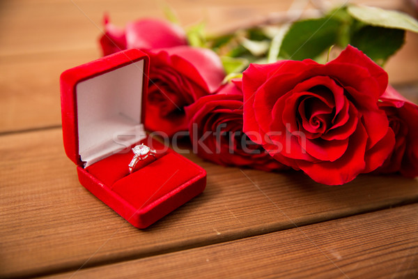 close up of diamond engagement ring and red roses Stock photo © dolgachov