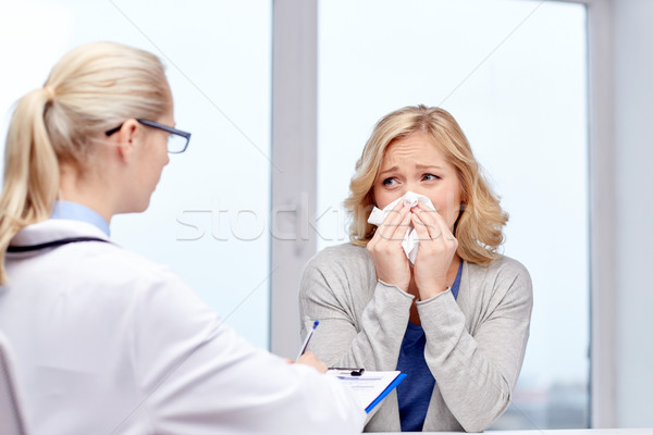 doctor and ill woman patient with flu at clinic Stock photo © dolgachov