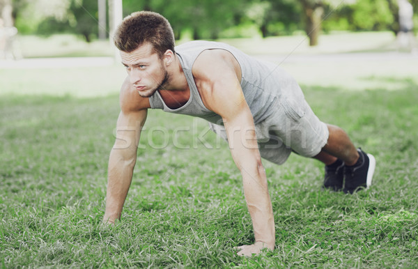 Młody człowiek pompek trawy lata parku fitness Zdjęcia stock © dolgachov
