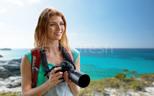 happy woman with backpack and camera over seashore Stock photo © dolgachov