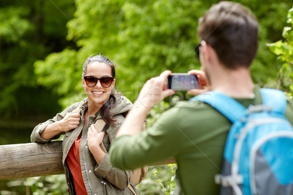 couple with backpacks taking picture by smartphone Stock photo © dolgachov