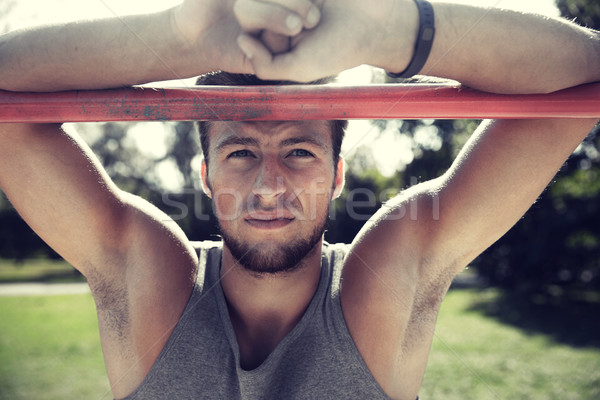 young man exercising on horizontal bar outdoors Stock photo © dolgachov