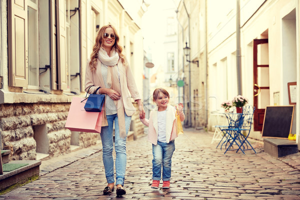 happy mother and child with shopping bags in city Stock photo © dolgachov