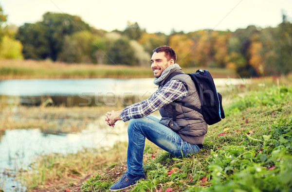 Gülen adam sırt çantası nehir banka Stok fotoğraf © dolgachov