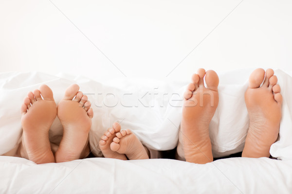 bare soles of happy family feet in bed at home Stock photo © dolgachov