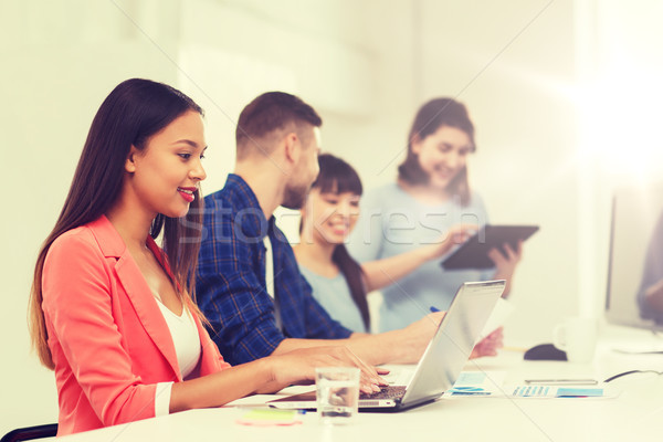 happy african woman over creative team at office Stock photo © dolgachov