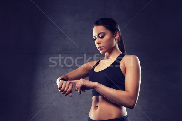 Stock photo: young woman with heart-rate watch in gym