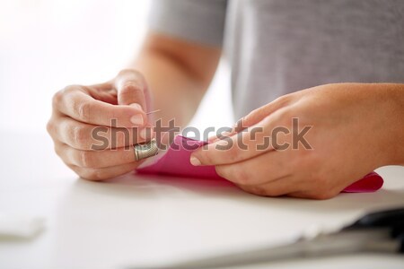 woman with needle stitching fabric pieces Stock photo © dolgachov