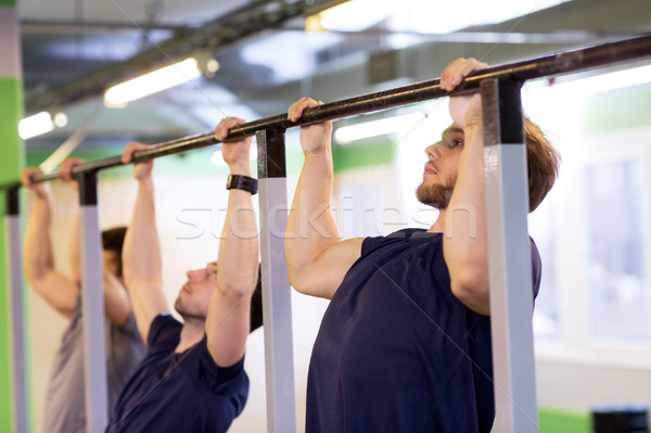 group of young men doing pull-ups in gym Stock photo © dolgachov