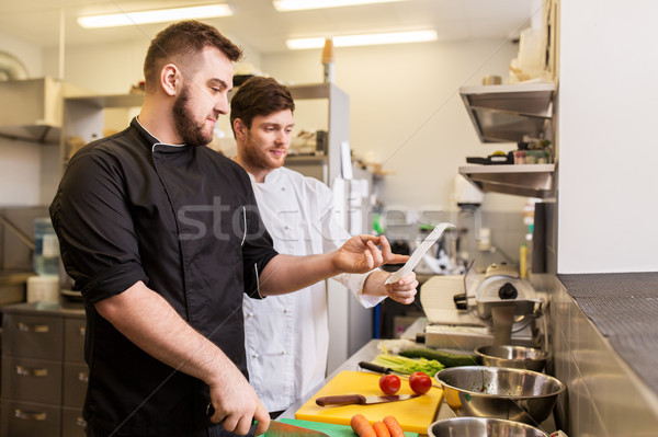 two chefs cooking food at restaurant kitchen Stock photo © dolgachov